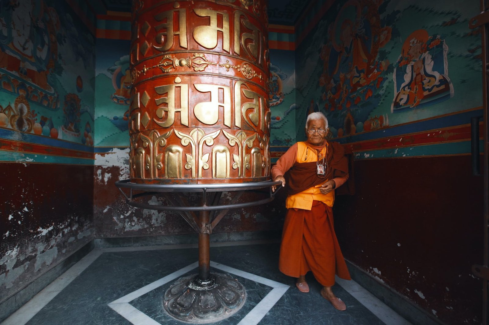 senior monk standing in an ornamental interior - tengboche monastery